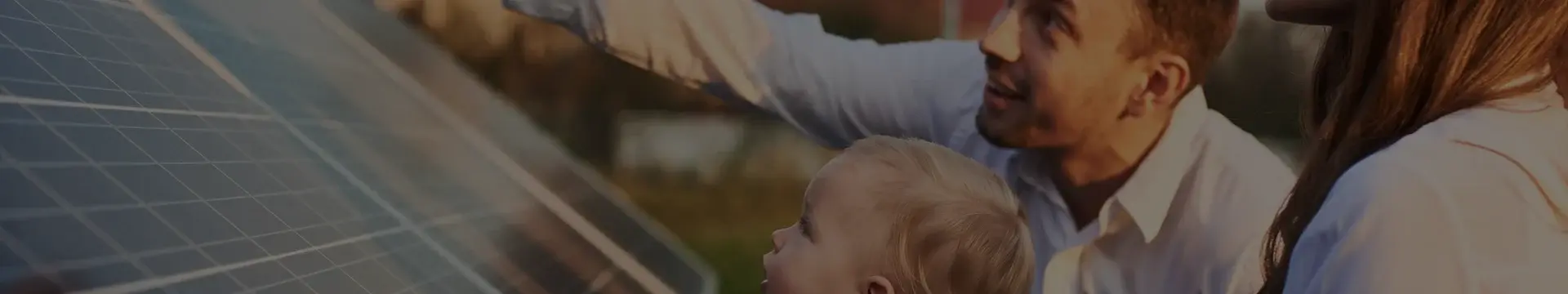 Man , woman and child closely inspecting solar panels